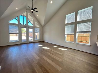 The view from the family room reveals a spacious kitchen with a large island at the center, perfect for gathering and meal prep. Sleek cabinetry, modern appliances, and ample natural light create a warm and inviting space for the whole family.