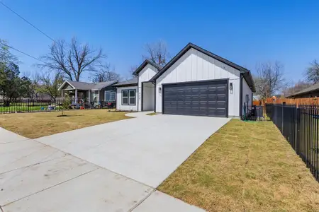 Modern farmhouse style home with concrete driveway, an attached garage, fence, and board and batten siding