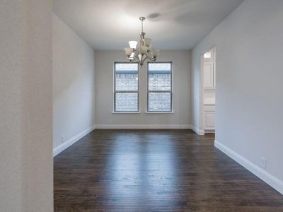 Empty room with an inviting chandelier and dark hardwood / wood-style flooring