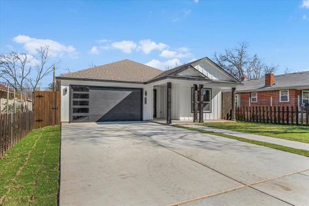 View of front of property featuring a garage, fence, concrete driveway, roof with shingles, and board and batten siding