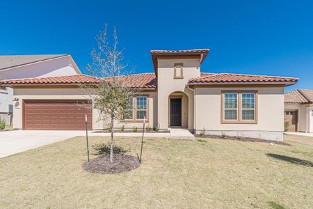 Mediterranean / spanish house featuring a garage, driveway, a tiled roof, stucco siding, and a front lawn