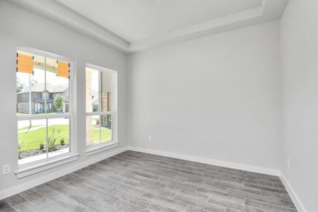 Make memories gathered around the table with your family and friends in this spacious dining room. Features elegant flooring,  custom paint, and large windows for ample natural light. Sample photo of completed home with similar floor plan. As-built interior colors and selections may vary.