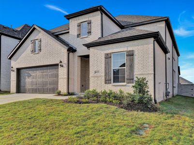 View of front of home with a garage and a front yard