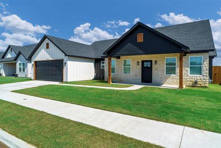 View of front of house with a garage and a front lawn