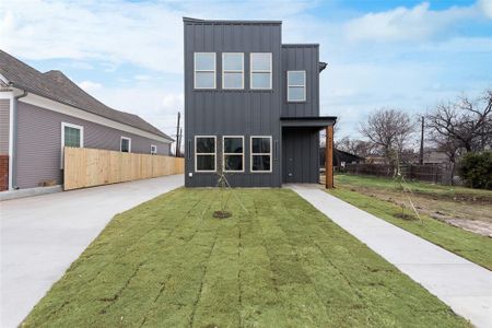 Rear view of house with a lawn, fence, and board and batten siding