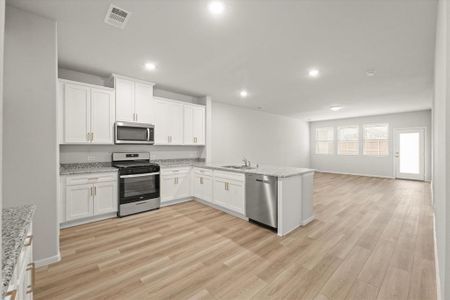 Kitchen featuring white cabinets, kitchen peninsula, appliances with stainless steel finishes, and sink