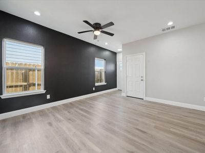 Empty room with ceiling fan and light hardwood / wood-style floors