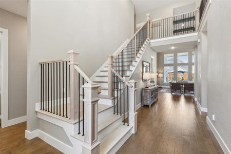 Stairway with a towering ceiling and wood-type flooring