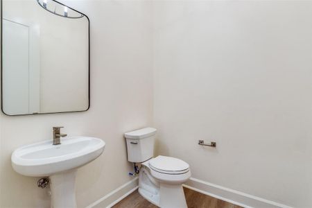 Bathroom with hardwood / wood-style flooring and toilet