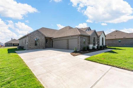 View of front of home featuring central AC, a front lawn, and a garage