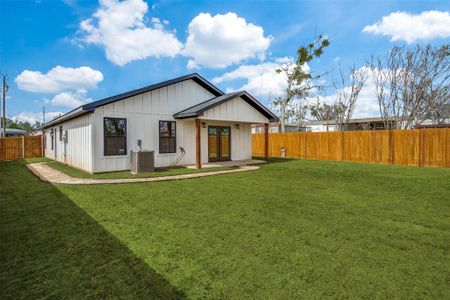 Back of house with a yard, a fenced backyard, french doors, central air condition unit, and board and batten siding