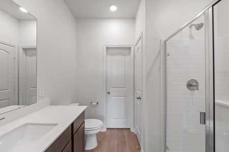 Full bath with a stall shower, vanity, toilet, and wood finished floors