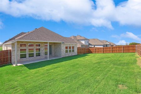 Rear view of house featuring a lawn and a patio