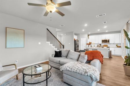 Living room with ceiling fan and light hardwood / wood-style flooring