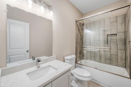 Full bathroom featuring hardwood / wood-style flooring, vanity, toilet, and bath / shower combo with glass door