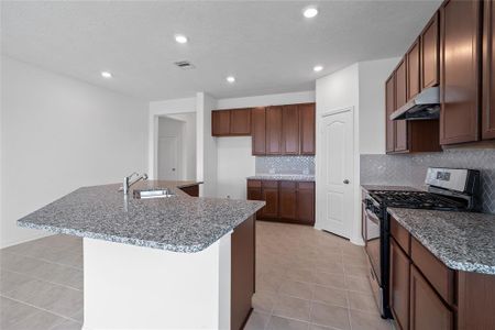 This kitchen is by far any chef’s dream! This spacious kitchen features high ceilings, dark stained wood cabinets, granite countertops, SS appliances, modern tile backsplash, recessed lighting, extended counter space, granite kitchen island with double sink, space for breakfast bar, and a walk-in pantry all overlooking your huge family room.