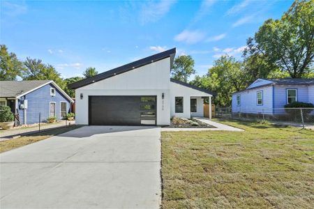 View of front of property with a front yard and a garage