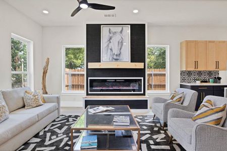 Living room featuring a large fireplace, ceiling fan, and light hardwood / wood-style floors