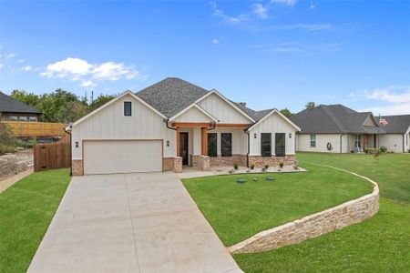 View of front facade featuring a garage and a front lawn