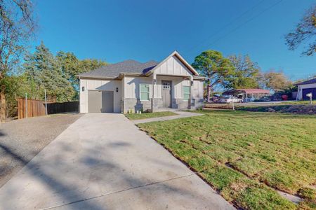 View of front of home with a garage and a front lawn