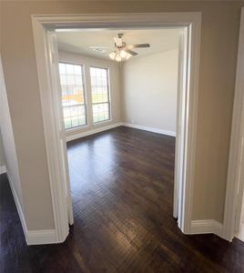 Unfurnished room featuring ceiling fan and dark hardwood / wood-style flooring