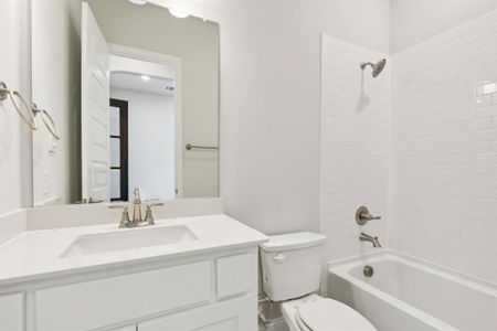 Full bathroom featuring toilet, vanity, and tiled shower / bath