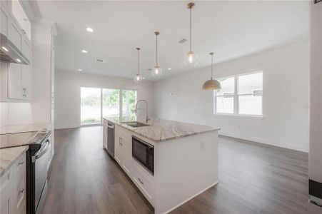 Cook's kitchen with ample counter/prep space on the quartz countertops. Specific finish colors may be differ. Photo is from another completed unit.