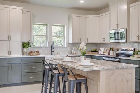 Kitchen featuring stainless steel appliances, a kitchen island, backsplash, and gray cabinetry