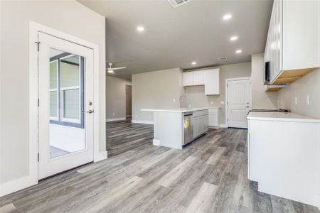 Kitchen featuring light wood-type flooring, an island with sink, and ceiling fan