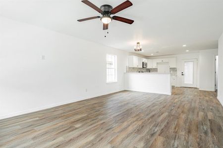 Unfurnished living room with light wood-type flooring and ceiling fan