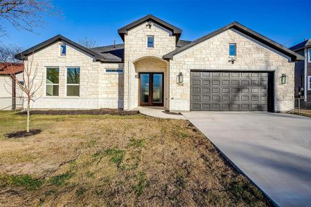 View of front of house with a garage and a front lawn