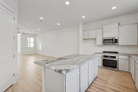 Kitchen with visible vents, recessed lighting, stainless steel appliances, light wood-style floors, and backsplash