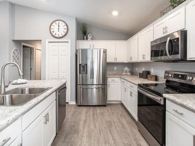 Open kitchen with 36 in. shaker-style cabinets, and Samsung SS appliances - Photo showcases a home with similar finishes. Colors and design options in actual home for sale may differ. Furnishing and décor items not included.