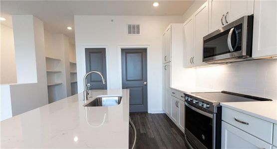 Main level living features bright white kitchen with soft closet cabinets and under counter lighting  *Home is Under Construction. Photos shown are from other TPG Communities to display how the home will live*