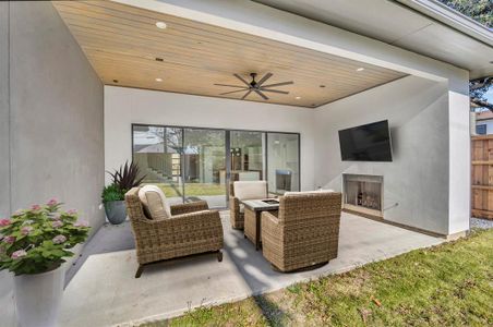 View of patio with an outdoor living space with a fireplace and ceiling fan