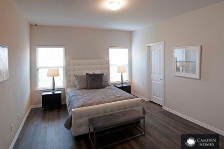 Bedroom featuring dark wood-type flooring and multiple windows