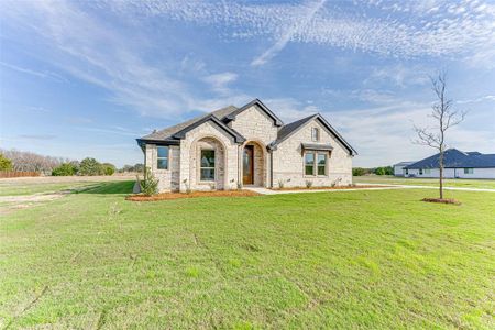 French country inspired facade with a front yard