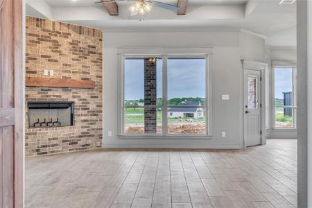 Unfurnished living room featuring ceiling fan, light hardwood / wood-style flooring, a brick fireplace, and plenty of natural light