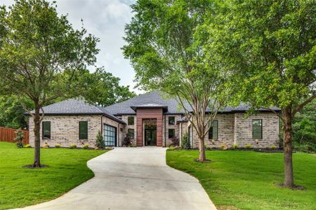 View of front of home with a garage and a front lawn