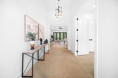 Step through the entrance to discover a haven of warmth, featuring gorgeous wood flooring, a fresh neutral color palette, and contemporary lighting that bathes the open-concept floor plan in an inviting glow