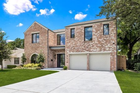 View of front facade featuring a front yard and a garage