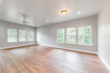 Empty room with light hardwood / wood-style flooring and ceiling fan