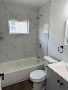 Secondary bathroom has tub with shower head plus tile surround to ceiling