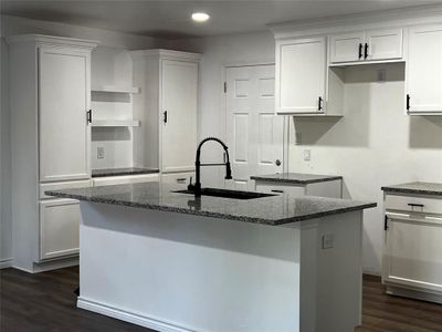 Kitchen with sink, white cabinets, a center island with sink, and dark hardwood / wood-style flooring