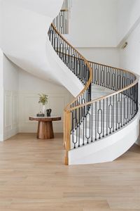 Step into luxury with a custom iron stair railing that gracefully winds up to marble steps, adding an elegant touch to your home.