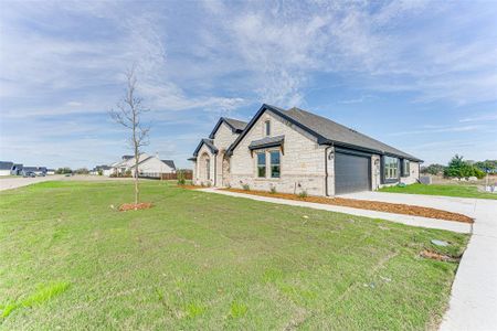 View of front of house with a garage and a front lawn