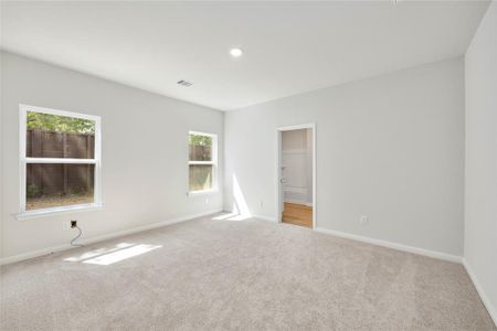 Large, primary bedroom with beautiful windows.