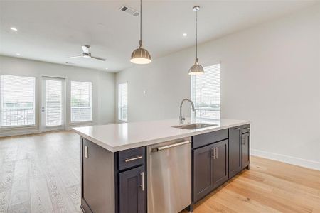 The open kitchen is bathed in natural light from large windows on both sides, creating a bright and welcoming atmosphere.