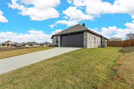 View of property exterior with a garage and a lawn