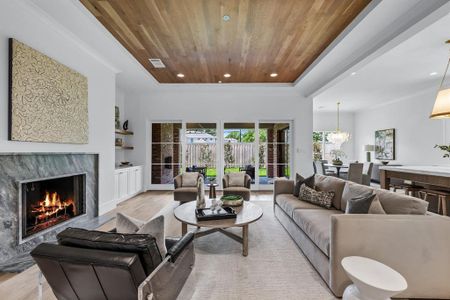 Living room with an inviting chandelier, light hardwood / wood-style floors, a fireplace, and wood ceiling